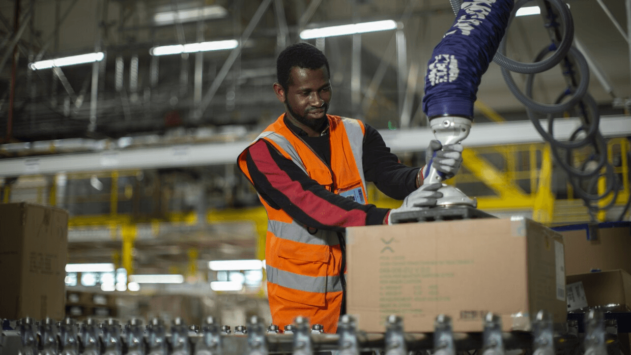 Warehouse worker in safety vest packaging shipments on the line